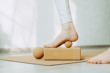 Foot on cork massage ball for plantar fascia MFR. Concept: self care practices at home, sustainable...