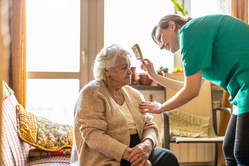 Female nurse taking care of a senior woman at home
