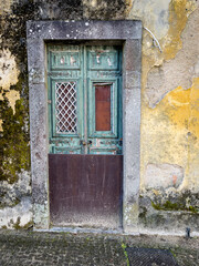 Derelict Weathered Wooden Doors. With Strong Stone Border And Yellow Peeling Wall, Braga, Portugal.