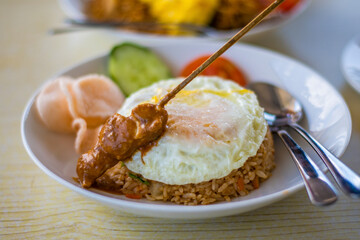 Nicely decorated platter lunch served in a white plate on a wooden table in touristic visit in Bali