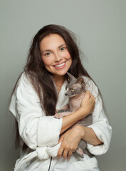 Happy woman with sphinx cat on white in the morning