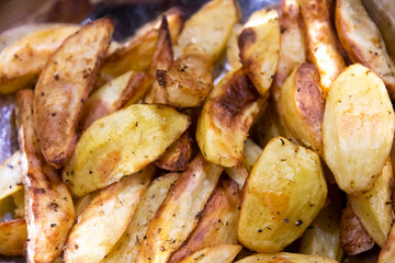 Crispy oven-baked potatoes. Delicious potatoes with herbs for dinner just out of the oven. Close up. 