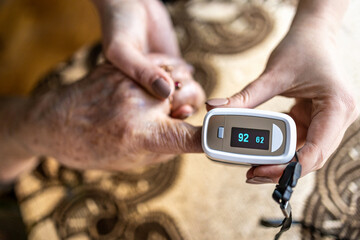 Senior woman using pulse oximeter
