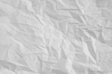 Gray crumpled sheet of rough paper closeup texture blank background.