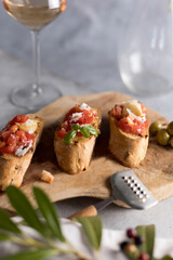 Homemade Italian Bruschetta Appetizer with Basil ,Tomatoes , parmesan ,olivien and glass of rose wine .
 Mediterranean Kitchen