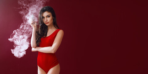 Young sexy woman in red body is vaping.