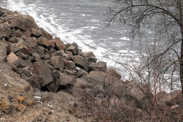 A very small beautiful frozen lake surrounded by large stone rocks. A flooded stone quarry. Lake Canyenne.