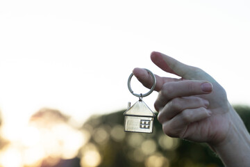 key chain in the form of a house in your hand of buying a home