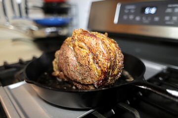 Prime rib roast baked on a cast iron skillet in a home kitchen.