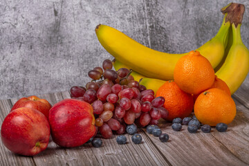 berries and ripe fruits on dark wood background
