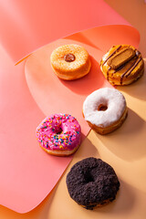 Mix of donuts on pink and caramel swirled background
