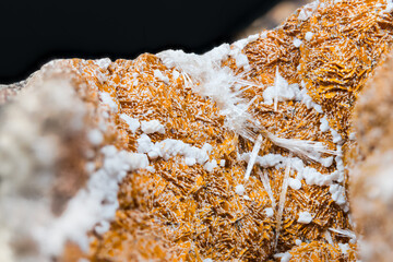 Detail of orange and white aragonite with clusters of crystals on black background. Close-up of beautiful texture of mineral from calcium carbonate. Collectable item: Hridelec near Nova Paka, Czechia. - obrazy, fototapety, plakaty