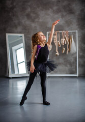 little girl ballerina in a black tutu at the machine