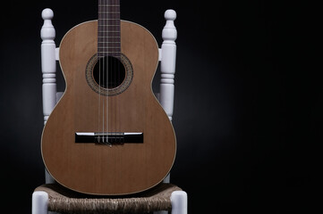 Spanish Guitar Supported On A White Enea Chair