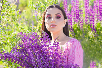 Young brunette woman with colorful summer flowers outdoors