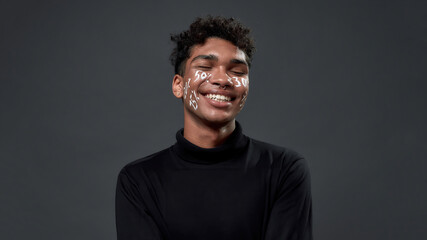 Portrait of happy young boy with percents on face