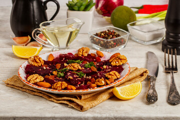 Beetroot salad with nuts raisins and lemon on light gray background. Close-up.  Healthy eating, vegetarian food.