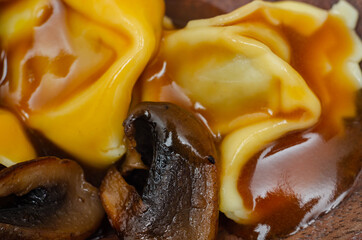 Close-up on fresh egg pasta with ricotta cheese and porcini mushrooms paste filling, delicious tortelloni