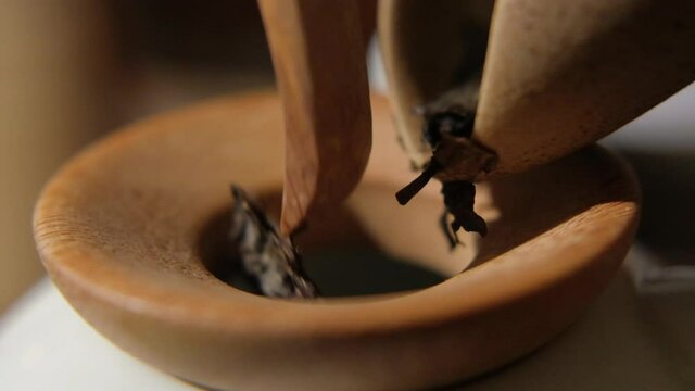 The tea master pours tea from the chahe into the teapot. Slow motion close-up, macro shot. Traditional Chinese tea drinking ceremony. Chinese Japanese tea, Puer Shu Gong Ting Xiao Tocha Oolong Zhang