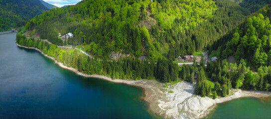Aerial panorama of Petrimanu Lake and a stream flowing in it. Two cabins were built on the lake's...