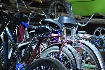 Fototapeta na wymiar Three serviceable bicycles in the barn stand against the wall.