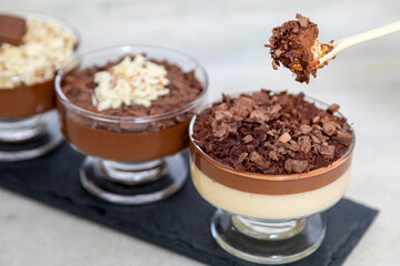 Chocolate mousse on spoon with white chocolate shavings