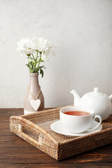 Wicker tray with hot tea on wooden table
