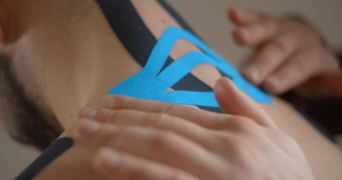 Kinesiologist sticks tapes to the neck of patient, recovery of an athlete after injury, kinesiotapes in the therapy of osteochondrosis, , 4k 60p Prores HQ 10 bit