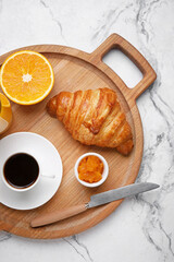 Wooden tray with tasty breakfast on light background