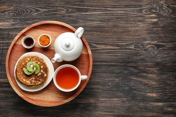 Tray with tasty breakfast on wooden background
