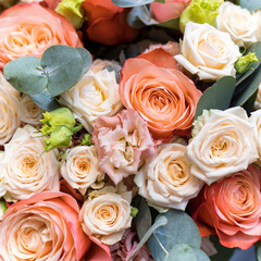 Wedding bouquet of orange and white roses, lisianthus and eucalyptus.