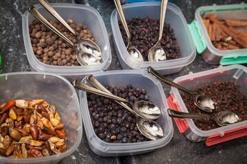 Three types of spices in containers with spoons.