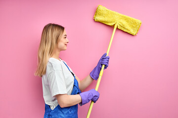side view on young housewife cleaning wall