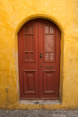 Fototapeta na wymiar Colorful walls and wooden door in Rhodes old town, Dodecanese, Greece