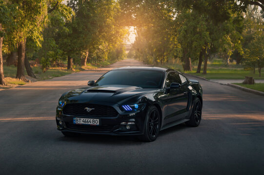 Kherson, Ukraine - July 2018. American muscle car Ford Mustang in a black color with blue headlights.