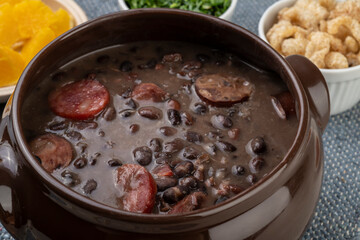 Traditional brazilian feijoada with cracklings, kale and orange