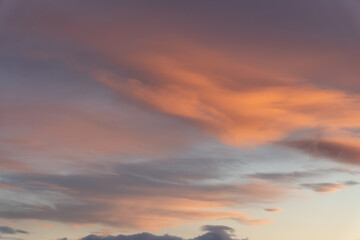A stunning orange winter sunset for cloud replacement with pastel coloring and cloudy covered sky with blue poking through. 