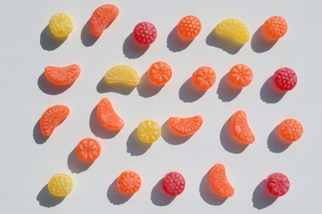Set of colorful fruit candies on white background. Flat lay summer composition. Hard light, shadow