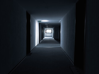 dark corridor with a light window at the end