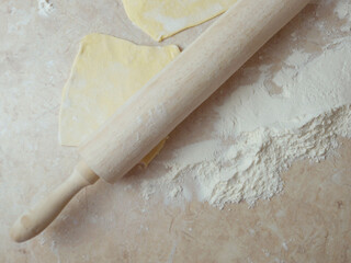 flour, dough and wooden rolling pin on table top view food background