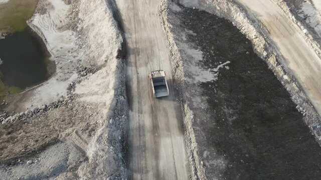 Aerial view shot, open pit mine, dumpers, quarrying extractive industry, stripping work. High quality 4k footage