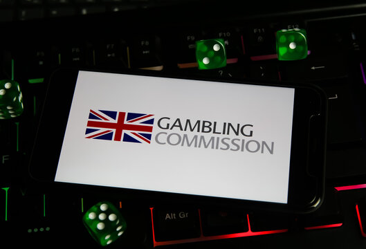 Viersen, Germany - March 1. 2021: Closeup Of Smartphone With Logo Lettering Of Uk Gambling Commission Licencing Authority On Computer Keyboard