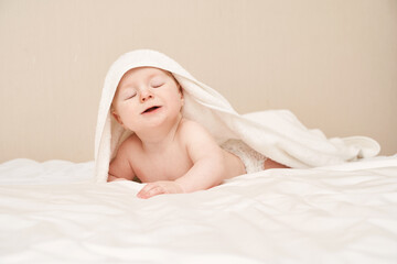 Cute small boy lying at bed. Childhood bath concept. Light background. Little child. Serious calm emotion. Copyspace. Stay home. Towel mockup. Closed eyes