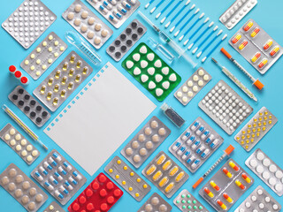 flatley, a layout of medicines in blisters with thermometers and syringes on a blue background