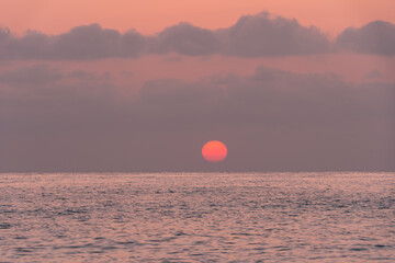 A sunrise scene over the Mediterranean sea when the sun is dim and just above the horizon