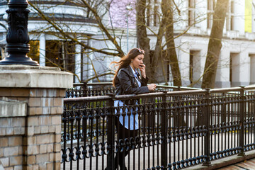 slim emotional dark-haired teenager woman in a city park on a sunny day