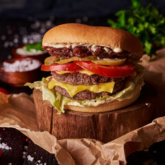 Very delicious and tasty juicy burger or cheeseburger on dark restaurant background. fast food concept banner photo with copyspace.