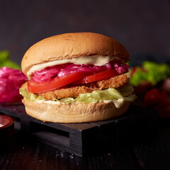 Very delicious and tasty juicy burger or cheeseburger on dark restaurant background. fast food concept banner photo with copyspace.