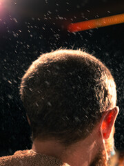 Male getting water sprayed on his head by a barber. 