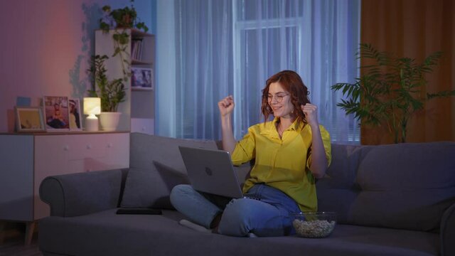 emotional girl is excited watching lottery or sports match and happily reacts to good news on Internet or will readily win